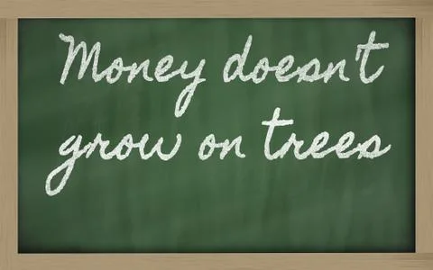 Expression -  money doesn't grow on trees - written on a school blackboard wi Stock Photos