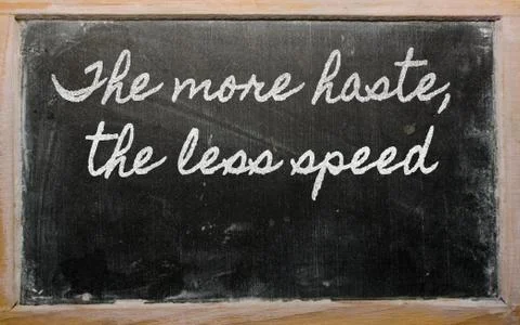 Expression -  the more haste, the less speed - written on a school blackboard 库存插图