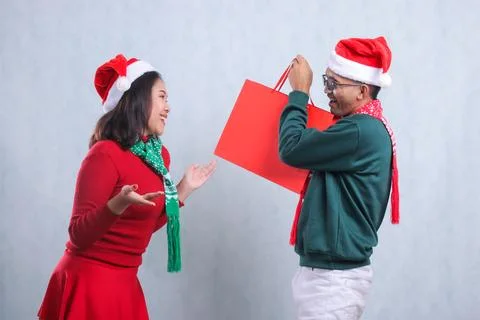 Expression of two people wearing Christmas sweaters, Santa hats and scarves.. Stock Photos