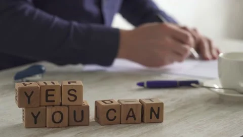 Expression YES YOU CAN put cubes. Man crosses out proposals in document, cru Stock Footage 156935573