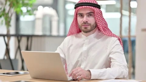 Expressionless Arab Businessman with Laptop Looking at Camera Stock Footage 139412844