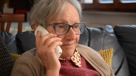 Expressive elderly lady speaks on the phone Stock Footage 150761338
