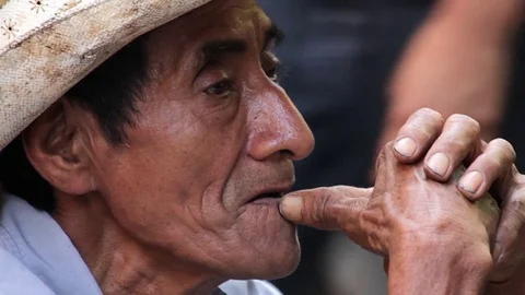 Expressive face of an old man, he plays with his hands while he rests. Stock Footage 69776783