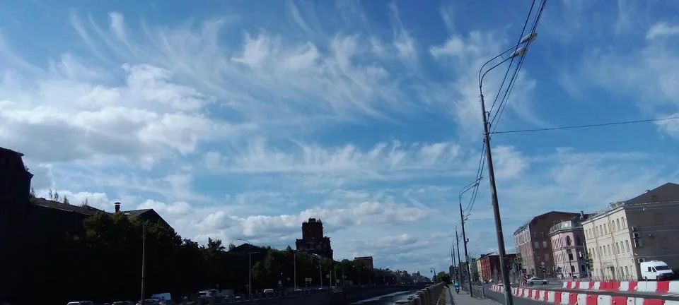 Expressive feather clouds with a waterfront in the background Stock Photos