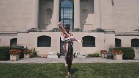 Expressive gender fluid model dancing outside museum Stock Footage 331597313
