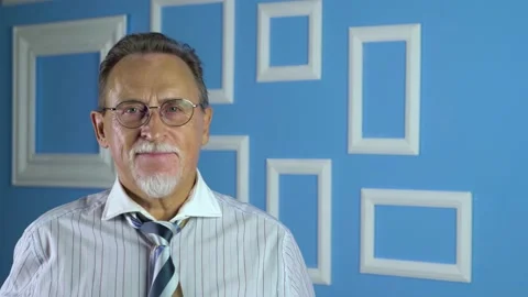  Expressive good looking senior man against bright wall at home Видео 134924268