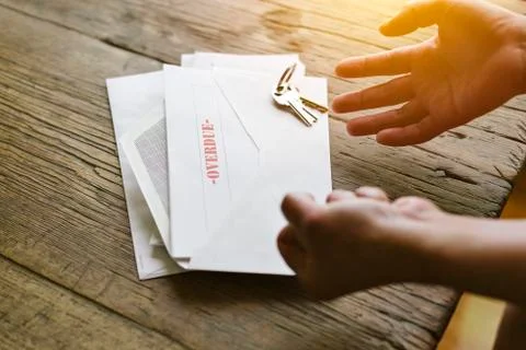 Expressive hands react to an overdue letter in an envelope - Financial hardsh Stock Photos