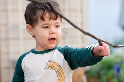 Expressive little boy playing in the backyard and making faces Stock Photos