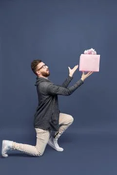 Expressive man offering wrapped present Stock Photos