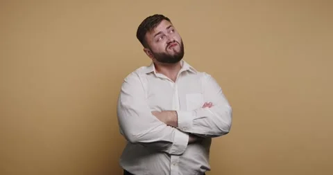 Expressive man showcases a range of funny facial reactions against a warm y.. 動画素材 329110353