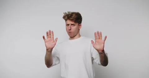 Expressive man uses hand gestures to convey different emotions in a simple .. Stock Footage 317327816