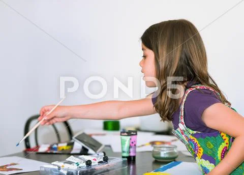 Expressive portrait of a pretty young girl doing paint with her mom Stock Photos