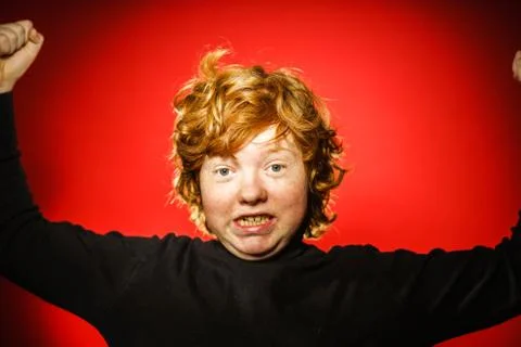 Expressive red-haired teenage boy showing emotions in studio Stock Photos