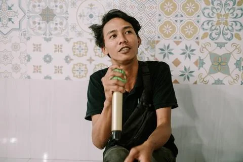 Expressive Singer Holding a Microphone in Front of Decorative Wall Stock Photos