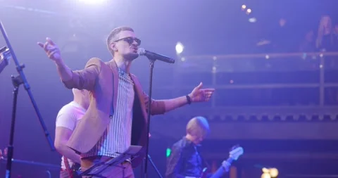 Expressive singer men in glasses singing into microphone. Live music concert in Stock Footage 194972364