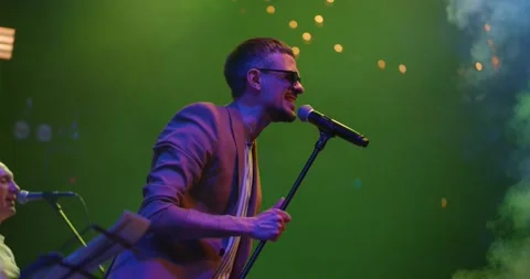 Expressive singer men in glasses singing into microphone. Live music concert in Stock Footage 194972436