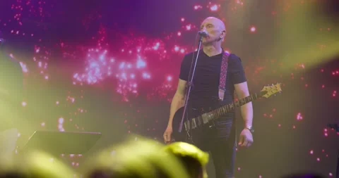 Expressive singer singing into microphone. Live music concert in front of bright Stock Footage 154913944