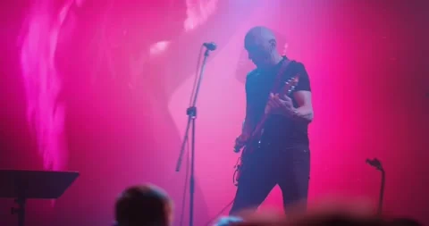 Expressive singer singing into microphone. Live music concert in front of bright Stock Footage 154914073