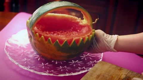 Expressive watermelon handle arching over mixed fruit in profile, 4K Vidéo 341114715