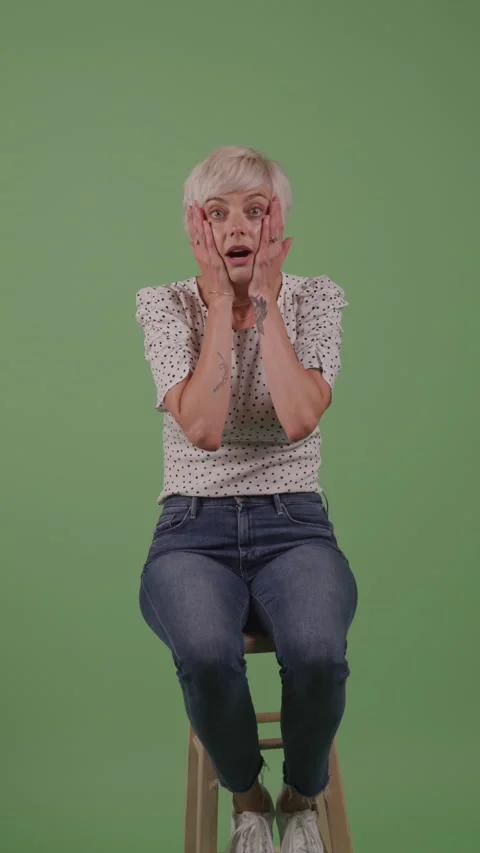 Expressive Woman in Front of Green Backdrop Is Shocked Stock Footage 219543701