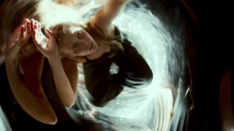 Expressive Woman Moving Gracefully in Distorted Mirror Reflections Stock Footage 306986783