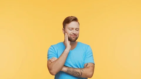 Expressive young man having pain over vibrant background. Studio portrait of Stock Footage 123778705