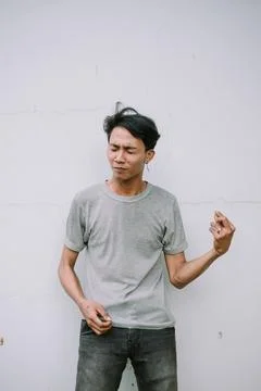 Expressive young man making a gesture against a white wall background Stock-Fotos