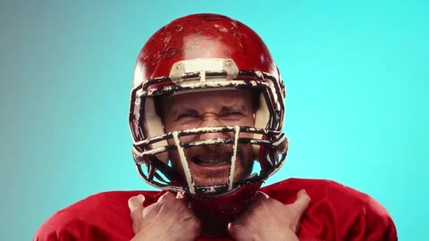 Expressive young man n in red football helmet, American football player Stock Footage 263433970
