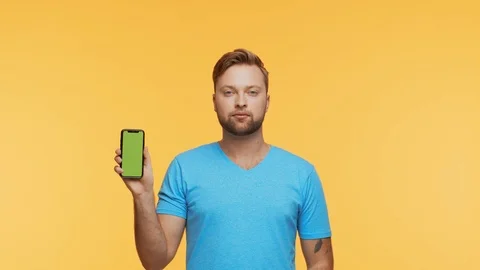 Expressive young man with a smartphone over vibrant background. Portrait of Stock Footage 123660384