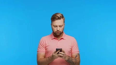 Expressive young man with a smartphone over vibrant background. Portrait of Stock Footage 123660439