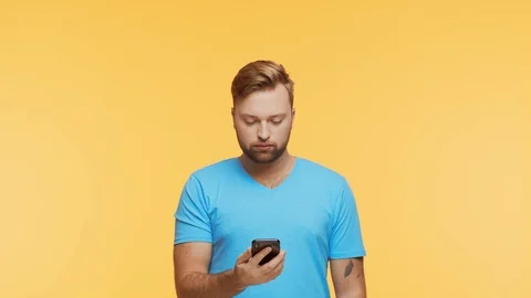 Expressive young man with a smartphone over vibrant background. Portrait of Stock Footage 123859309