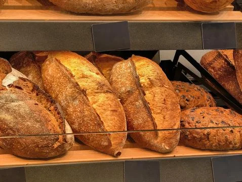 Exquisite artisan breads displayed in a rustic bakery, inviting customers to Stock Photos