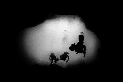Exquisite B&amp;W image of scuba divers underwater lava tube cave black and white Stock Photos