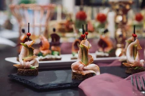 Exquisite canapes of ham or salmon with herbs on rye bread Stock Photos