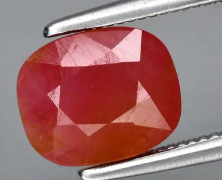 Exquisite Close-up of a Lustrous Ruby Gemstone Held by Precise Silver Tweezer 写真素材