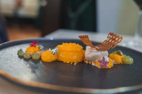 Exquisite Dessert with Vibrant Orange Elements and Edible Flowers in Luxury.. 写真素材