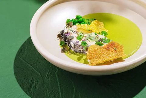 Exquisite dish featuring crispy elements and vibrant green sauce Stockfoto's