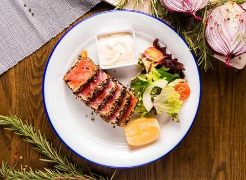Exquisite seared tuna steak chunks, complemented by a refreshing salad and .. Stock Photos