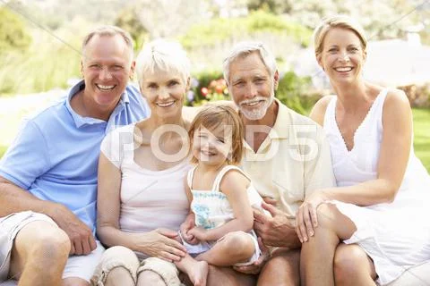 Extended Family Relaxing In Garden Stock Photos