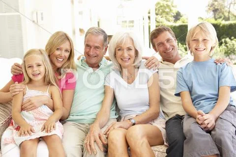 Extended Family Relaxing Together On Sofa Stock Photos