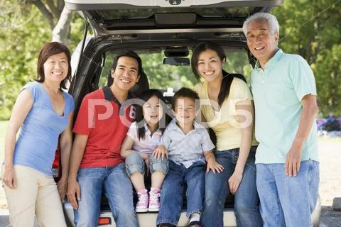 Extended family sitting in tailgate of car Stock Photos