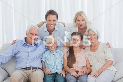 Extended family sitting together on couch Stock Photos
