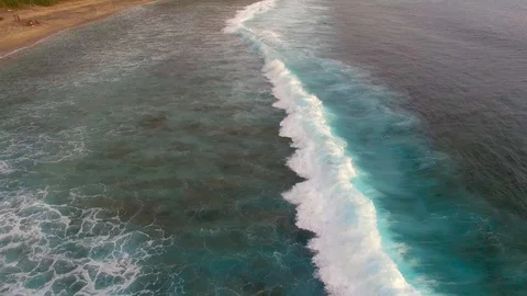 Extended orbiting shot of waves breaking on a tropical beach at sunset Stock Footage 93781606