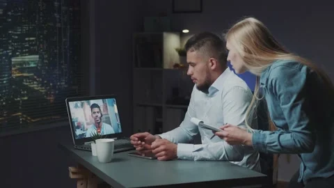 Extended videoconferencing between two directors on computer late at night. Stock-Footage 157599188