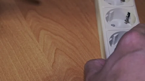 Extender ockets, electrical appliance plug and watt meter on a wooden surface Stock Footage 102913673