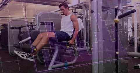 Extending legs man using leg-extension machine in gym, wearing white tank, blue 스톡 사진