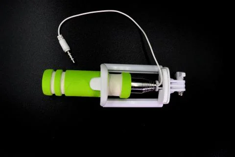 An extensible selfie stick with an adjustable clamp on the end on a white bac Stock Photos