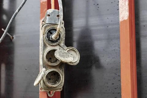 Extension cord, electrical socket, power cord old and damaged on the construc Stock Photos