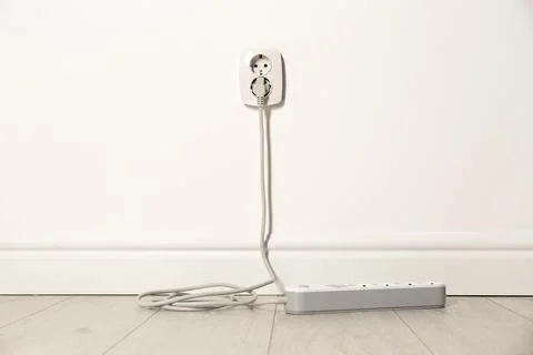 Extension cord with power plug in socket indoors. Electrician's professional  Stock Photos