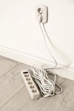 Extension cord with power plug in socket indoors. Electrician's professional  Stock Photos